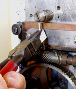 Once in position, push the tail end of the spring behind the retaining stud with a quick downward movement of the pliers